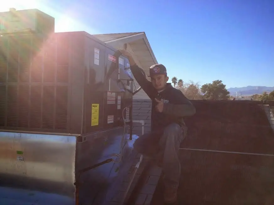HVAC technician performing Air Duct Cleaning on a rooftop unit in Centralia